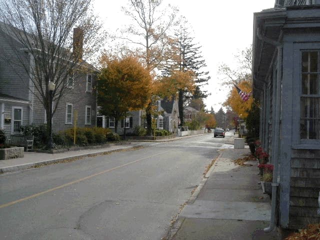 Autumn foliage lines a quiet village street of shingled homes in Marion.